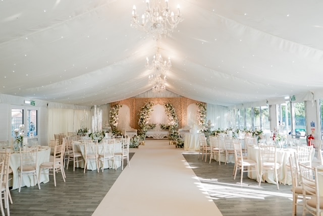 Elegant wedding chair hire and aisle setup in a London marquee