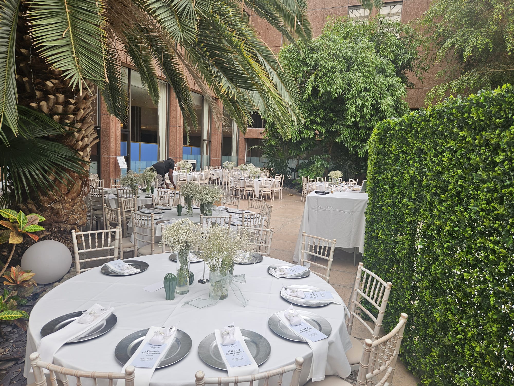 Outdoor event furniture setup with dressed tables and Chiavari chairs